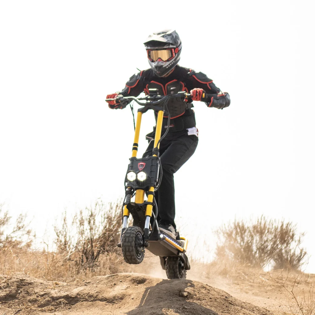 Rider jumping the e scooter Kaabo Wolf King GT Pro on an off-road dirt track, showcasing its powerful suspension and rugged design.