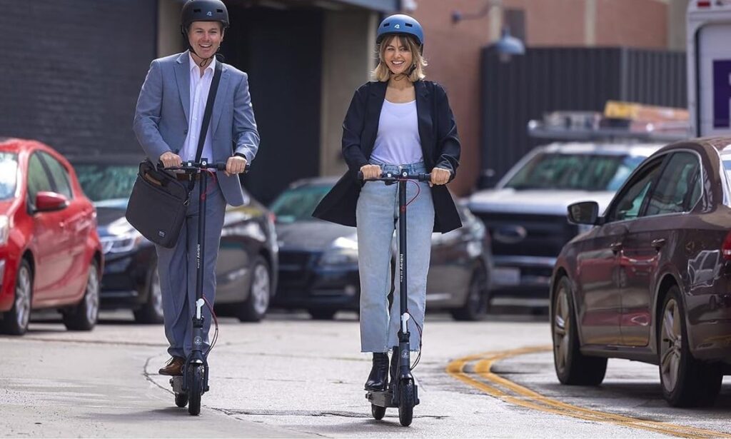 Two people riding the Hiboy S2 Pro electric scooter together, showcasing its smooth performance and comfortable city commuting design.
