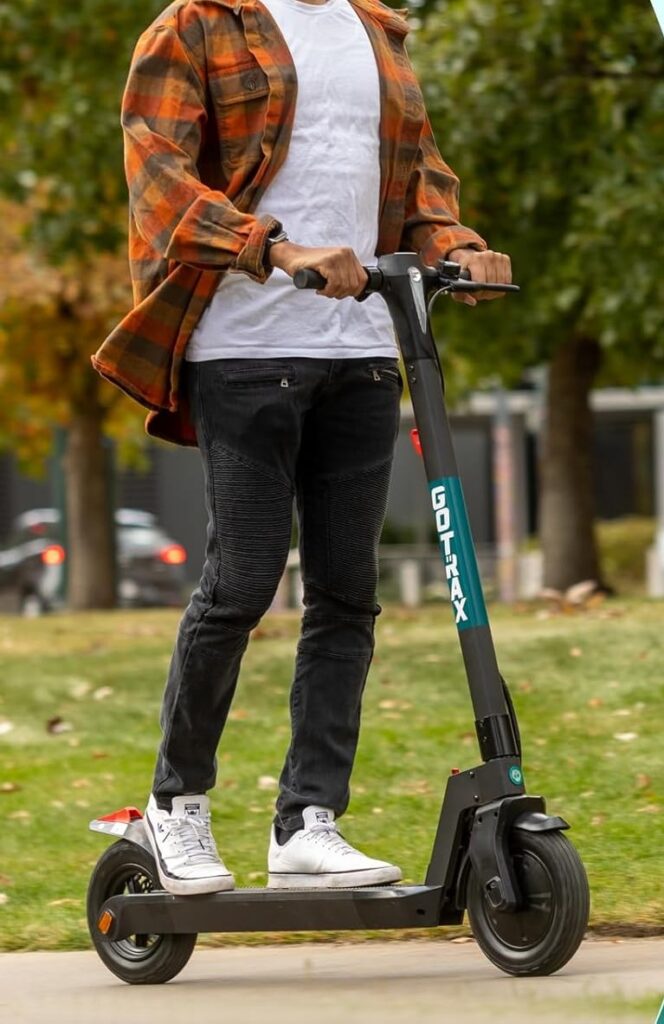 Man riding a GOTRAX electric scooter in a park, showcasing one of the best e scooters under $500.