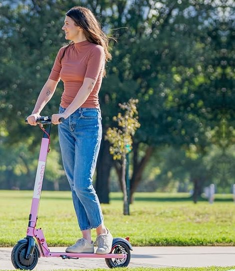 A woman riding the pink Gotrax GXL V2 in the park, highlighted as one of the best e scooters for hills with durable design and comfortable handling.