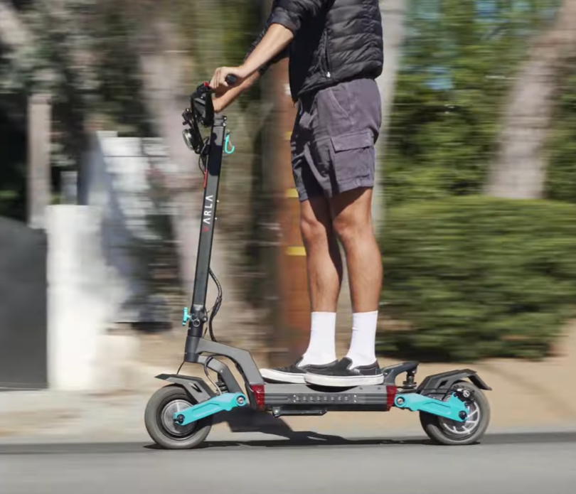 Person riding the best e scooter for hills Varla Eagle One V2.0, designed for off-road terrain and steep hill climbing.