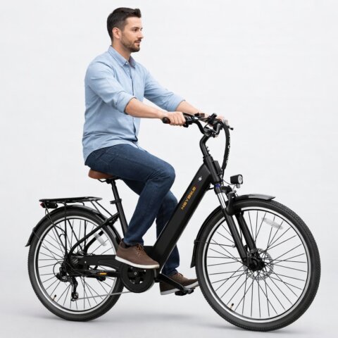 Man sitting on a black commuter electric bike in studio setting, representing one of the best budget e-bikes for beginners.